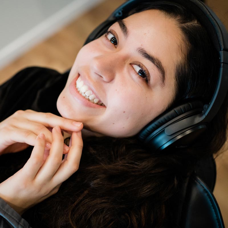 Photo of a smiling patient wearing headphones